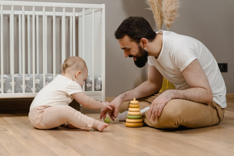 Papá y bebé jugando a un juego de ensartar de madera