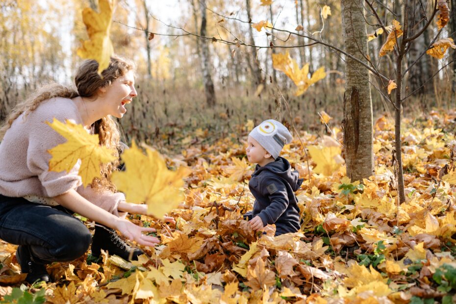 Niño gateando entre hojas del otoño